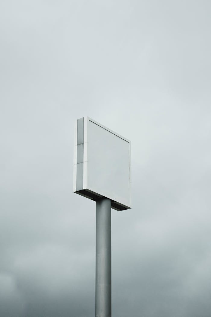 An empty billboard stands tall against a cloudy, overcast sky, perfect for mockup design.